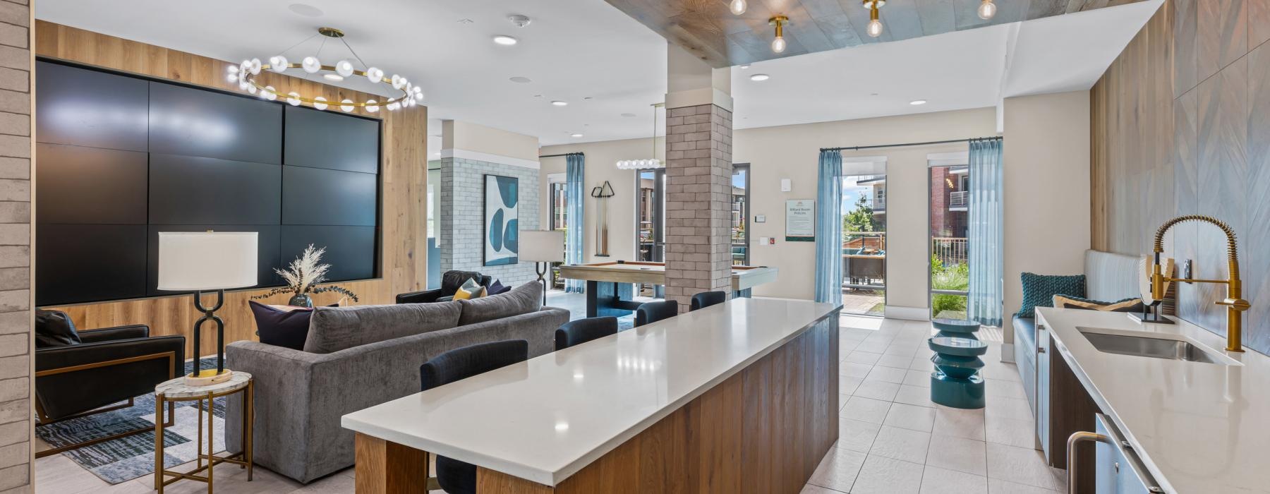 a lounge room with a kitchennette with a bar and a couch